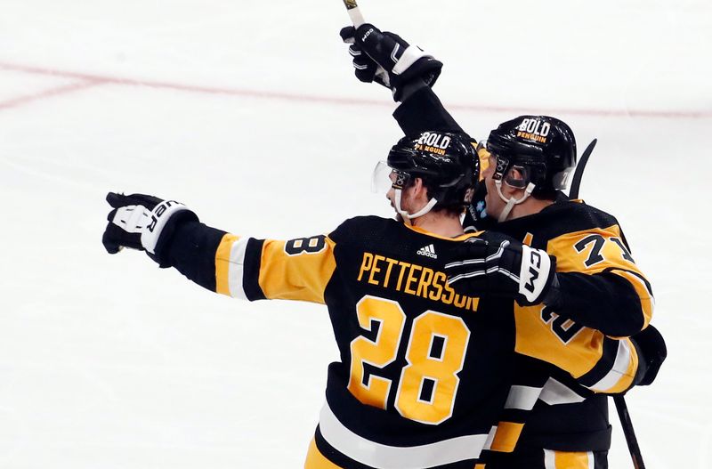 Jan 27, 2024; Pittsburgh, Pennsylvania, USA;  Pittsburgh Penguins defenseman Marcus Pettersson (28) celebrates his game winning overime goal with Pittsburgh Penguins center Evgeni Malkin (71) to defeat the Montreal Canadiens at PPG Paints Arena. The Penguins won 3-2 in overtime. Mandatory Credit: Charles LeClaire-USA TODAY Sports