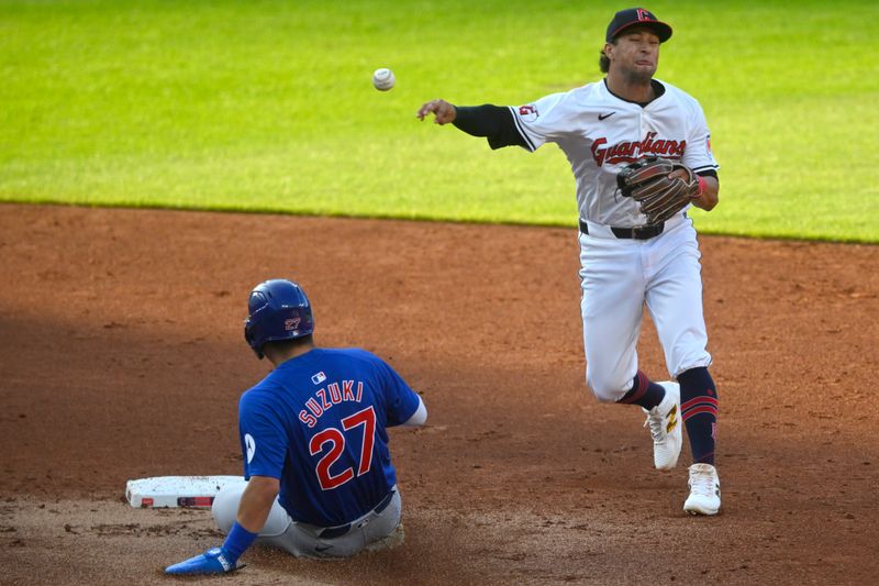 Aug 14, 2024; Cleveland, Ohio, USA; Cleveland Guardians shortstop Tyler Freeman (2) throws to first base beside Chicago Cubs right fielder Seiya Suzuki (27) in the third inning at Progressive Field. Mandatory Credit: David Richard-USA TODAY Sports