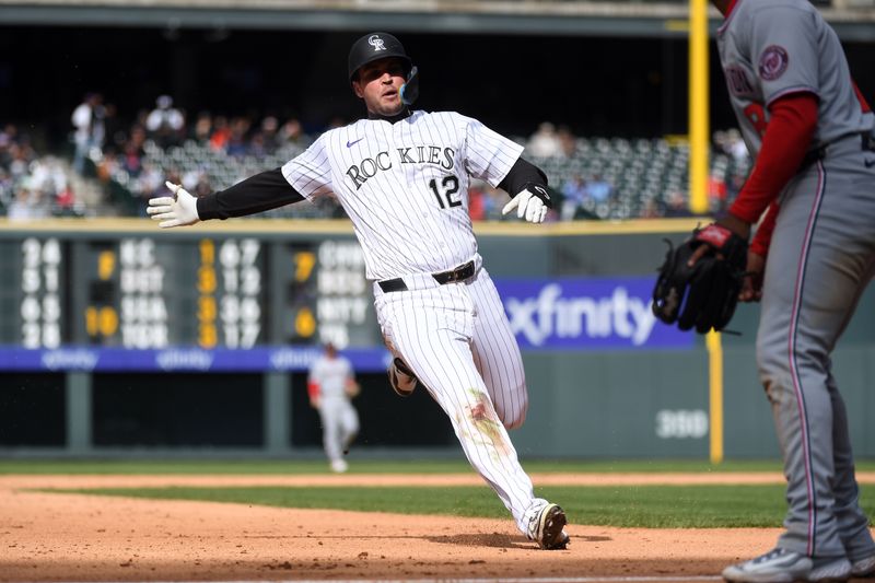 Apr 19, 2025; Denver, Colorado, USA; Colorado Rockies outfielder Sean Bouchard (12) slides into third base after an RBI triple during the seventh inning against the Washington Nationals at Coors Field. Mandatory Credit: Christopher Hanewinckel-Imagn Images