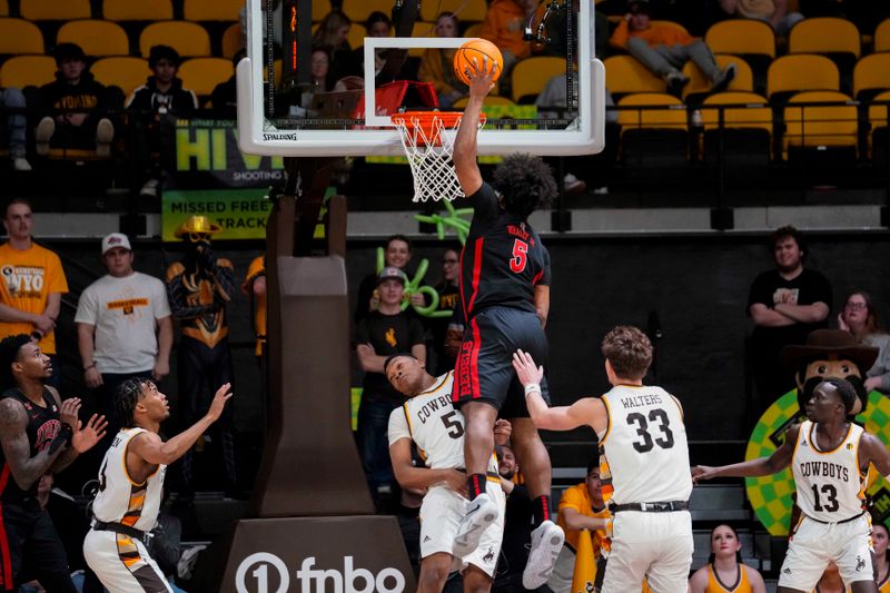 Feb 27, 2024; Laramie, Wyoming, USA; UNLV Runnin' Rebels guard Rob Whaley Jr. (5) dunks against Wyoming Cowboys forward Cam Manyawu (5) during overtime at Arena-Auditorium. Mandatory Credit: Troy Babbitt-USA TODAY Sports