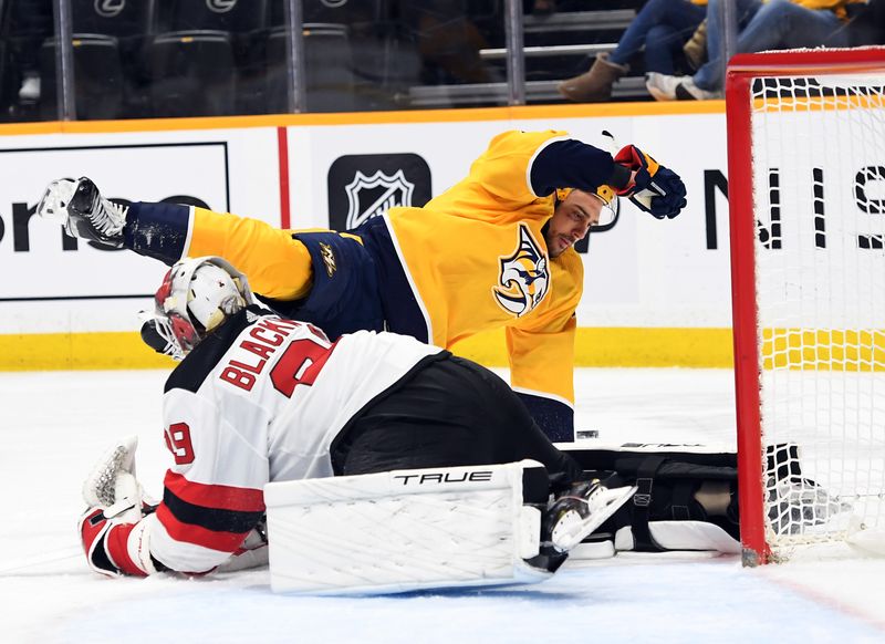 Jan 26, 2023; Nashville, Tennessee, USA; Nashville Predators right wing Nino Niederreiter (22) is tripped by New Jersey Devils goaltender Mackenzie Blackwood (29) on a scoring attempt during the first period at Bridgestone Arena. Mandatory Credit: Christopher Hanewinckel-USA TODAY Sports