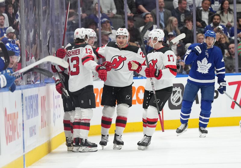 Mar 26, 2024; Toronto, Ontario, CAN; New Jersey Devils defenseman Luke Hughes (43) scores a goal and celebrates with New Jersey Devils center Nico Hischier (13) against the Toronto Maple Leafs during the first period at Scotiabank Arena. Mandatory Credit: Nick Turchiaro-USA TODAY Sports