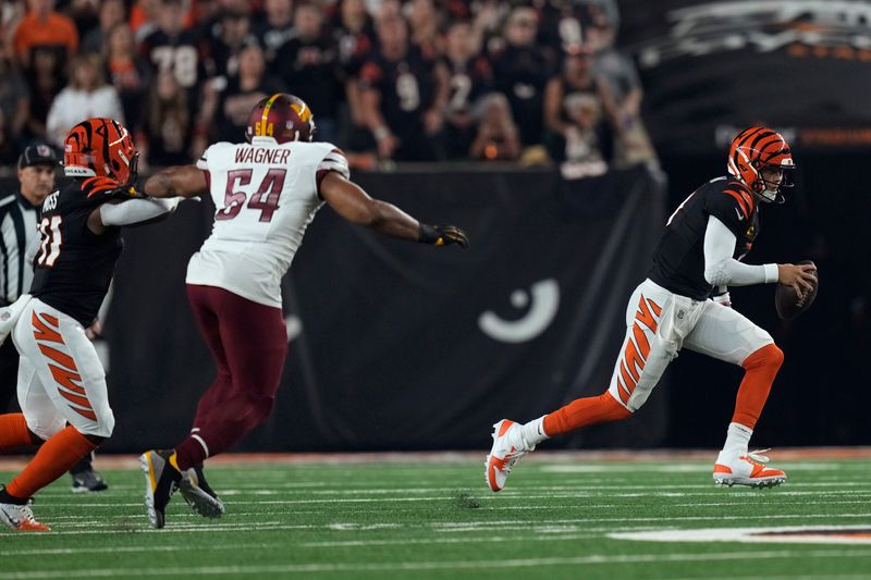 Cincinnati Bengals quarterback Joe Burrow runs from Washington Commanders linebacker Bobby Wagner (54) during the first half of an NFL football game, Monday, Sept. 23, 2024, in Cincinnati. (AP Photo/Carolyn Kaster)