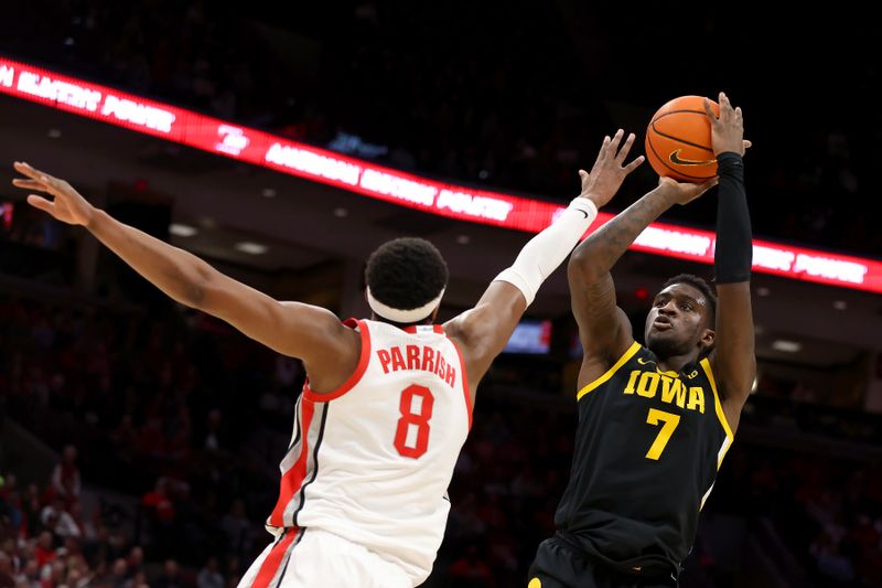 Jan 27, 2025; Columbus, Ohio, USA;  Iowa Hawkeyes forward Seydou Traore (7) shoots the ball as Ohio State Buckeyes guard Micah Parrish (8) defends during the first half at Value City Arena. Mandatory Credit: Joseph Maiorana-Imagn Images