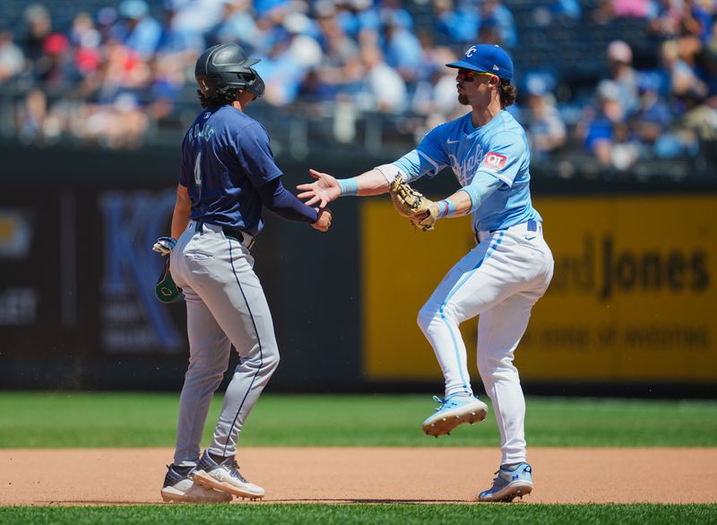 Jun 9, 2024; Kansas City, Missouri, USA; Seattle Mariners third baseman Josh Rojas (4) is caught in a rundown by Kansas City Royals shortstop Bobby Witt Jr. (7) during the seventh inning at Kauffman Stadium. Mandatory Credit: Jay Biggerstaff-USA TODAY Sports