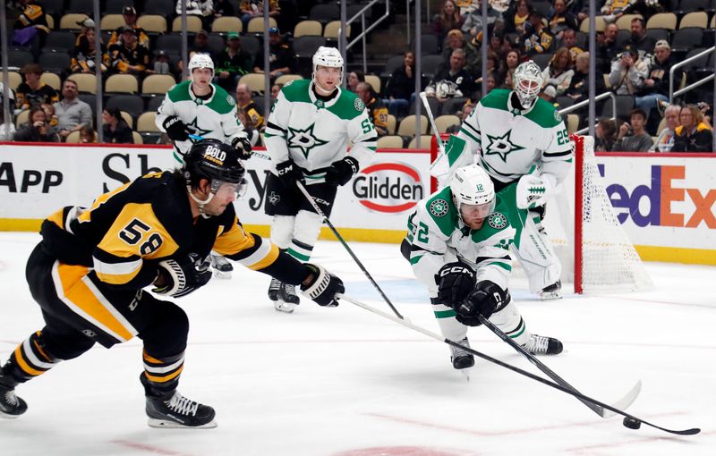 Oct 24, 2023; Pittsburgh, Pennsylvania, USA; Pittsburgh Penguins defenseman Kris Letang (58) and Dallas Stars center Radek Faksa (12) reach for the puck during the third period at PPG Paints Arena. Dallas won 4-1. Mandatory Credit: Charles LeClaire-USA TODAY Sports