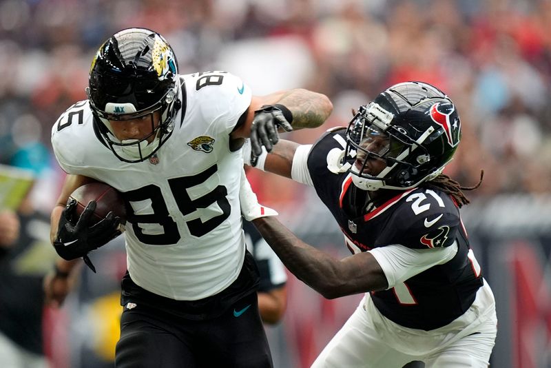 Jacksonville Jaguars tight end Brenton Strange (85) runs from Houston Texans safety Calen Bullock (21) after catching a pass during the first half of an NFL football game, Sunday, Sept. 29, 2024, in Houston. (AP Photo/Eric Gay)