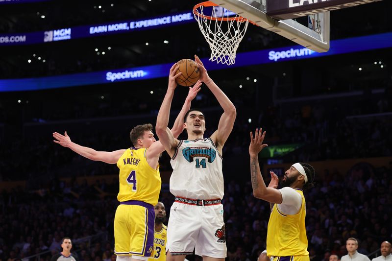 LOS ANGELES, CALIFORNIA - NOVEMBER 13: Zach Edey #14 of the Memphis Grizzlies shoots the ball between Dalton Knecht #4 and Anthony Davis #3 of the Los Angeles Lakers during the fourth quarter at Crypto.com Arena on November 13, 2024 in Los Angeles, California. NOTE TO USER: User expressly acknowledges and agrees that, by downloading and or using this photograph, User is consenting to the terms and conditions of the Getty Images License Agreement.  (Photo by Harry How/Getty Images)