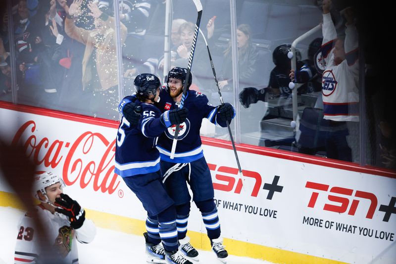 Oct 11, 2024; Winnipeg, Manitoba, CAN; Winnipeg Jets forward Mark Scheifele (55) is congratulated by Winnipeg Jets forward Kyle Connor (81) on his goal against the Chicago Blackhawks during the overtime period at Canada Life Centre. Mandatory Credit: Terrence Lee-Imagn Images