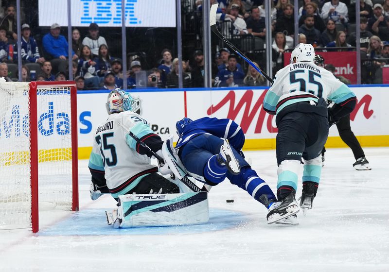 Oct 18, 2025; Toronto, Ontario, CAN; Toronto Maple Leafs center Max Domi (11) controls the puck defended by Seattle Kraken defenseman Ryan Lindgren (55) during the third period at Scotiabank Arena. Mandatory Credit: Nick Turchiaro-Imagn Images