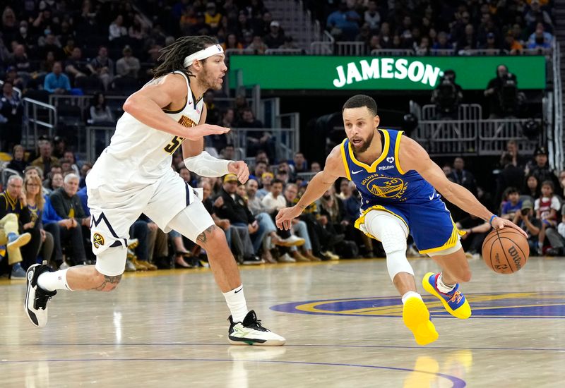 SAN FRANCISCO, CALIFORNIA - FEBRUARY 25: Stephen Curry #30 of the Golden State Warriors dribbling the ball is guarded by Aaron Gordon #50 of the Denver Nuggets during the third quarter of an NBA basketball game at Chase Center on February 25, 2024 in San Francisco, California. NOTE TO USER: User expressly acknowledges and agrees that, by downloading and or using this photograph, User is consenting to the terms and conditions of the Getty Images License Agreement. (Photo by Thearon W. Henderson/Getty Images)