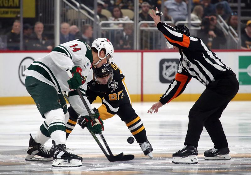 Oct 29, 2024; Pittsburgh, Pennsylvania, USA; Minnesota Wild center Joel Eriksson Ek (14) and Pittsburgh Penguins center Sidney Crosby (87) take the opening face-off during the first period at PPG Paints Arena. Mandatory Credit: Charles LeClaire-Imagn Images