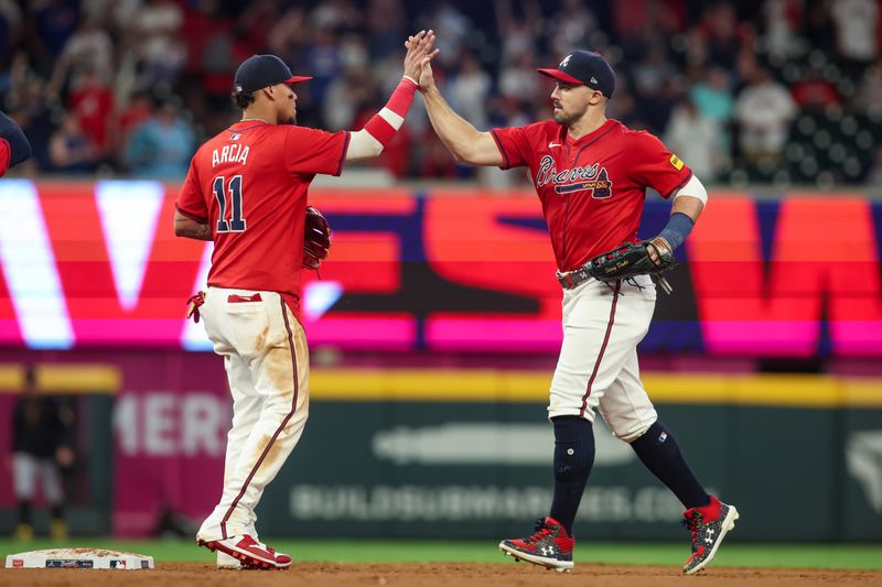 Jun 28, 2024; Atlanta, Georgia, USA; Atlanta Braves shortstop Orlando Arcia (11) and outfielder Adam Duvall (14) celebrate after a victory against the Pittsburgh Pirates at Truist Park. Mandatory Credit: Brett Davis-USA TODAY Sports