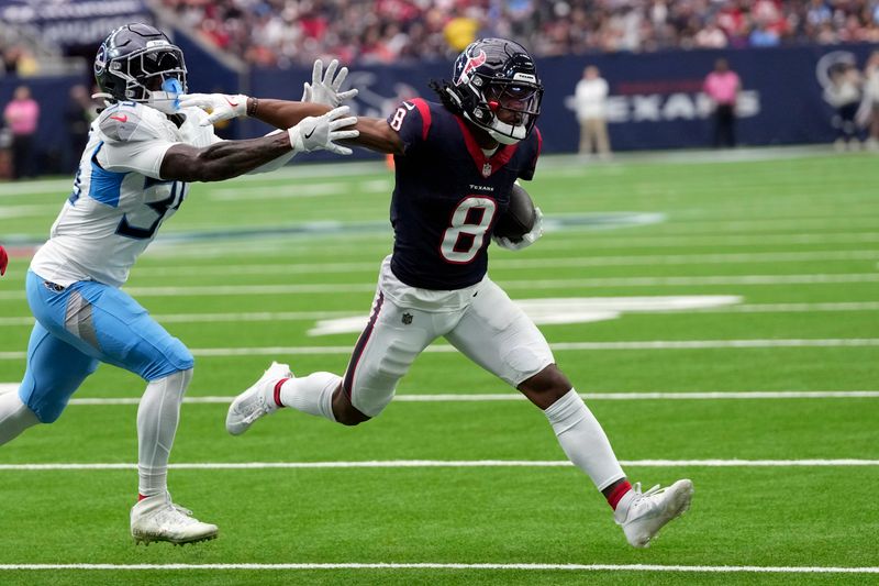 Houston Texans wide receiver John Metchie III (8) is forced out of bounds by Tennessee Titans safety K'Von Wallace after catching a pass during an NFL football game Sunday, Dec. 31, 2023, in Houston. (AP Photo/David J. Phillip)