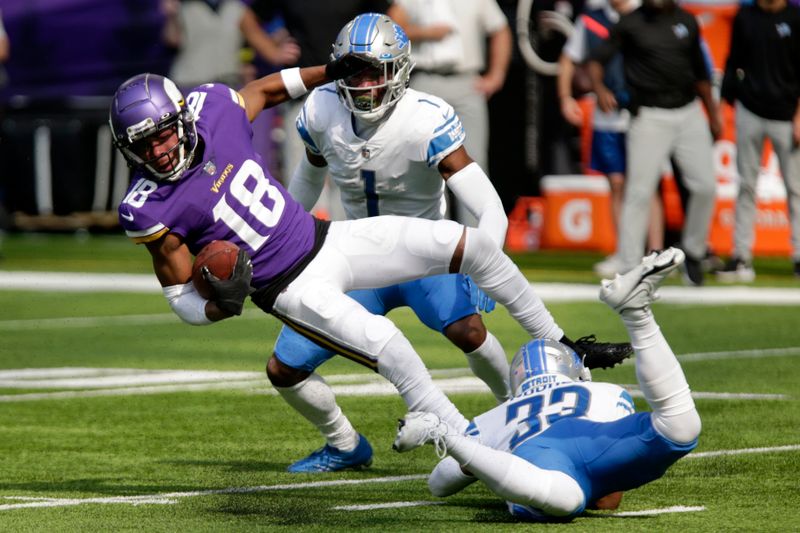 Minnesota Vikings wide receiver Justin Jefferson (18) is tackled by Detroit Lions cornerback Jeff Okudah (1) and safety JuJu Hughes (33) during the first half of an NFL football game, Sunday, Sept. 25, 2022, in Minneapolis. (AP Photo/Andy Clayton-King)