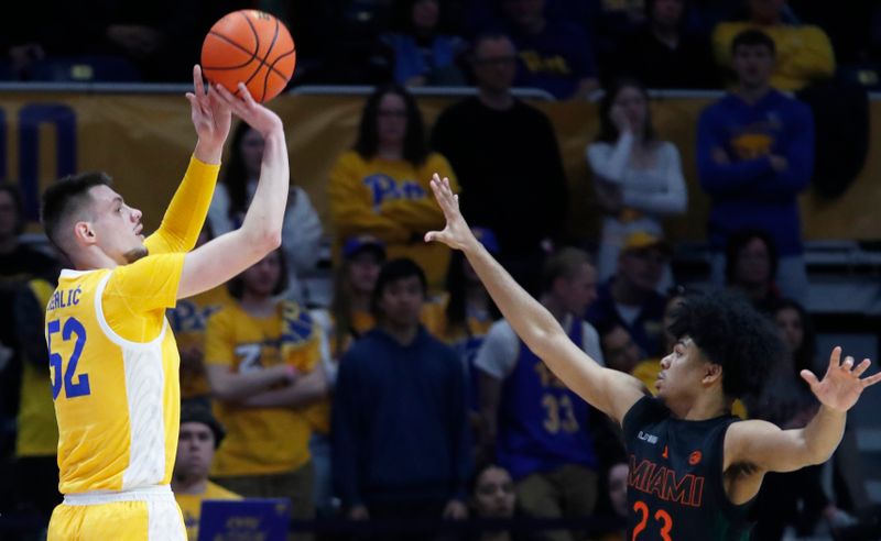 Feb 15, 2025; Pittsburgh, Pennsylvania, USA; Pittsburgh Panthers guard Amsal Delalic (52) shoots against Miami (Fl) Hurricanes guard Austin Swartz (23) during the first half at the Petersen Events Center. Mandatory Credit: Charles LeClaire-Imagn Images