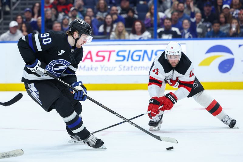 Nov 16, 2024; Tampa, Florida, USA; Tampa Bay Lightning defenseman J.J. Moser (90) controls the puck against the New Jersey Devils in the third period at Amalie Arena. Mandatory Credit: Nathan Ray Seebeck-Imagn Images