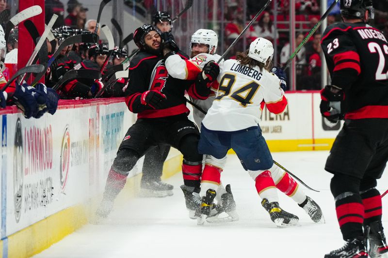 Mar 14, 2024; Raleigh, North Carolina, USA; Florida Panthers left wing Jonah Gadjovich (12) and left wing Ryan Lomberg (94) checks Carolina Hurricanes defenseman Jalen Chatfield (5) during the third period at PNC Arena. Mandatory Credit: James Guillory-USA TODAY Sports