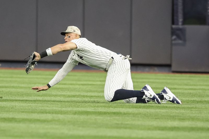 May 18, 2025; Bronx, New York, USA;  New York Yankees right fielder Aaron Judge (99) makes a diving catch in the second inning against the New York Mets at Yankee Stadium. Mandatory Credit: Wendell Cruz-Imagn Images
