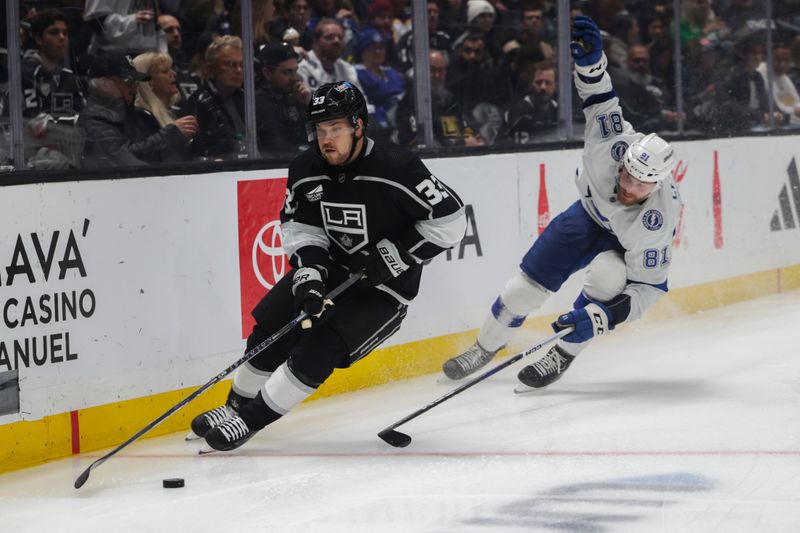 Mar 23, 2024; Los Angeles, California, USA; Los Angeles Kings right wing Viktor Arvidsson (33) moves the puck as Tampa Bay Lighting defensemen Erik Cernak (81) defends during the second period of an NHL hockey game at Crypto.com Arena. Mandatory Credit: Yannick Peterhans-USA TODAY Sports