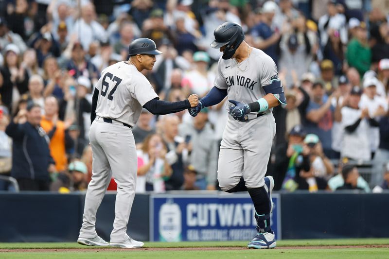 May 24, 2024; San Diego, California, USA;  New York Yankees center fielder Aaron Judge (99) celebrates with New York Yankees third base coach Luis Rojas (67) after hitting a one-run home run in the third inning against the San Diego Padres at Petco Park. Mandatory Credit: David Frerker-USA TODAY Sports