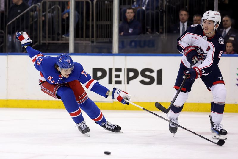 Feb 28, 2024; New York, New York, USA; Columbus Blue Jackets defenseman Zach Werenski (8) plays the puck against New York Rangers center Matt Rempe (73) during the second period at Madison Square Garden. Mandatory Credit: Brad Penner-USA TODAY Sports