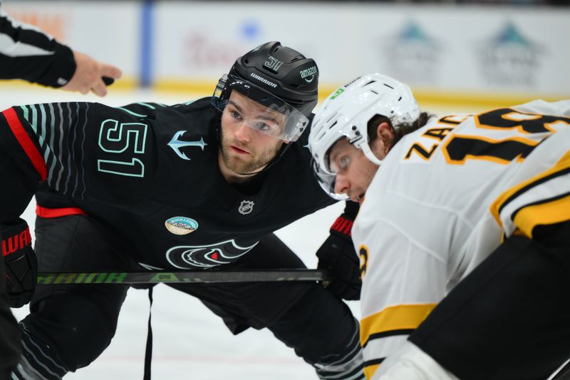 Jan 6, 2026; Seattle, Washington, USA; Seattle Kraken center Shane Wright (51) and Boston Bruins center Pavel Zacha (18) face-off during the second period at Climate Pledge Arena. Mandatory Credit: Steven Bisig-Imagn Images