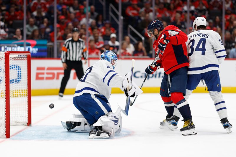 Oct 24, 2023; Washington, District of Columbia, USA; Toronto Maple Leafs goaltender Joseph Woll (60) makes a save in front of Washington Capitals left wing Alex Ovechkin (8) and Maple Leafs center Auston Matthews (34) in the third period at Capital One Arena. Mandatory Credit: Geoff Burke-USA TODAY Sports