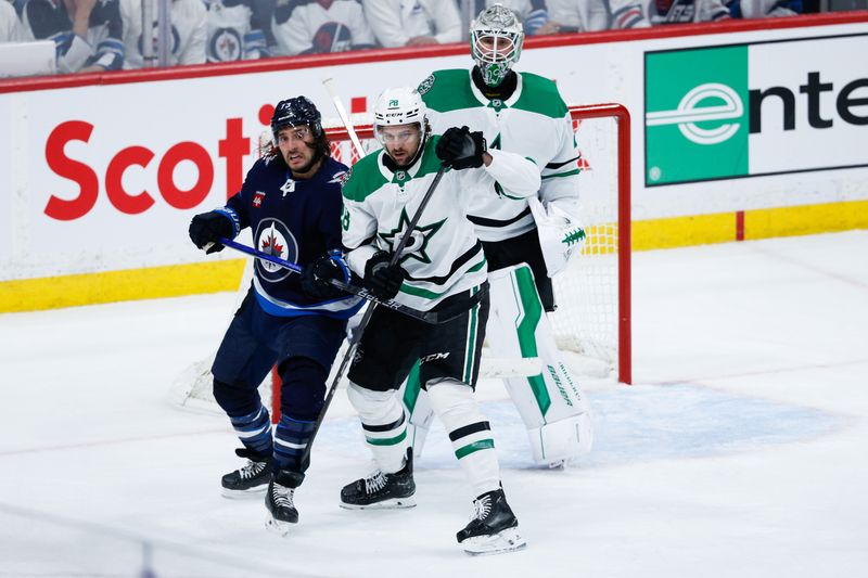 May 7, 2025; Winnipeg, Manitoba, CAN; Winnipeg Jets forward Brandon Tanev (73) jostles for position with Dallas Stars defenseman Alexander Petrovic (28) during the third period in game one of the second round of the 2025 Stanley Cup Playoffs at Canada Life Centre. Mandatory Credit: Terrence Lee-Imagn Images