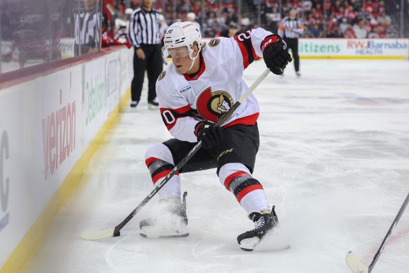 Mar 22, 2025; Newark, New Jersey, USA; Ottawa Senators left wing Fabian Zetterlund (20) plays the puck against the New Jersey Devils during the first period at Prudential Center. Mandatory Credit: Ed Mulholland-Imagn Images