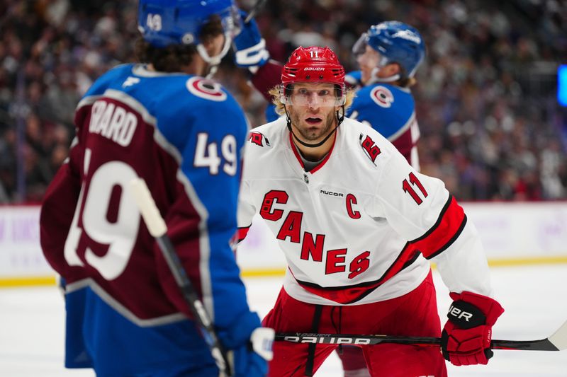 Nov 9, 2024; Denver, Colorado, USA; Carolina Hurricanes center Jordan Staal (11) stares at Colorado Avalanche defenseman Samuel Girard (49) in the first period at Ball Arena. Mandatory Credit: Ron Chenoy-Imagn Images