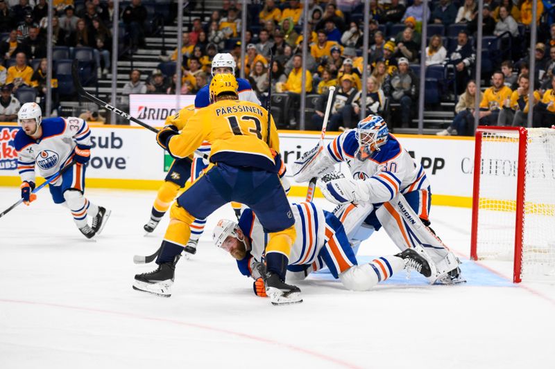 Oct 31, 2024; Nashville, Tennessee, USA;  Edmonton Oilers goaltender Calvin Pickard (30) blocks the shot of Nashville Predators center Juuso Parssinen (13) during the third period at Bridgestone Arena. Mandatory Credit: Steve Roberts-Imagn Images