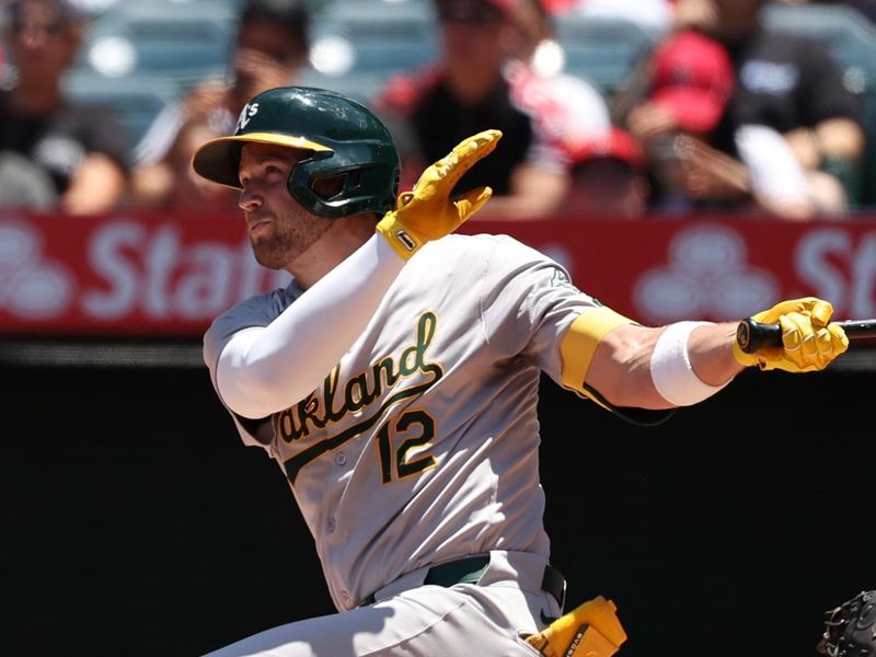 Jun 26, 2024; Anaheim, California, USA;  Oakland Athletics shortstop Max Schuemann (12) hits an RBI double against the Los Angeles Angels during the second inning at Angel Stadium. Mandatory Credit: Kiyoshi Mio-USA TODAY Sports