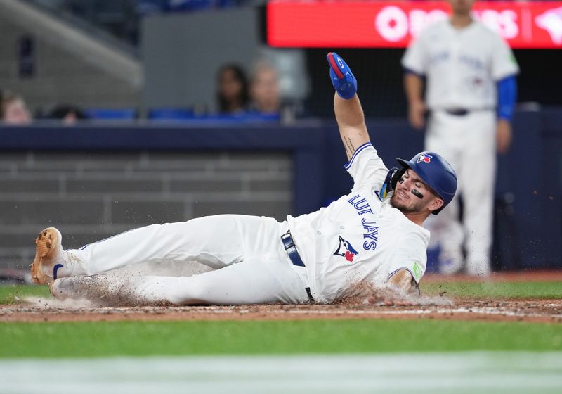 Jun 30, 2024; Toronto, Ontario, CAN; Toronto Blue Jays second baseman Spencer Horwitz (48) slides into home plate scoring a run against the New York Yankees during the third inning at Rogers Centre. Mandatory Credit: Nick Turchiaro-USA TODAY Sports