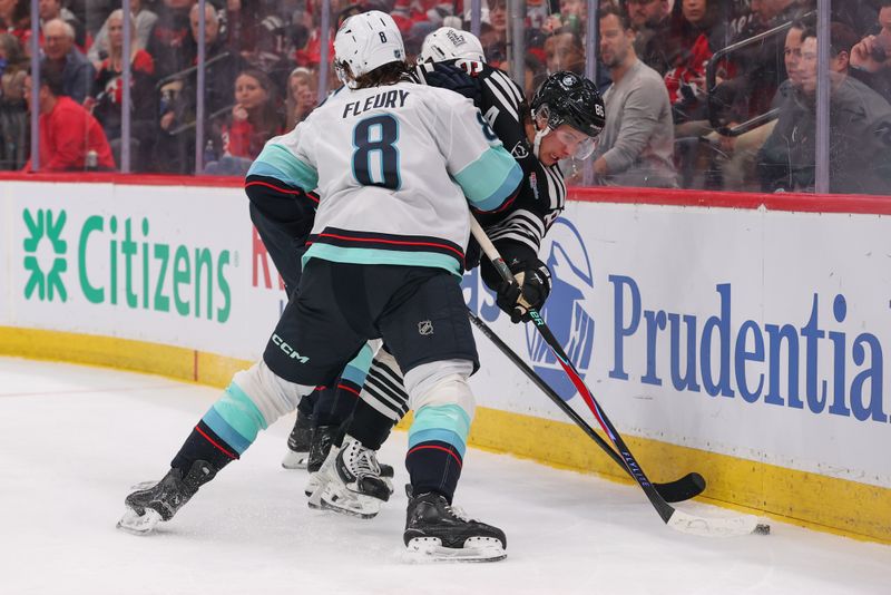Jan 14, 2026; Newark, New Jersey, USA; New Jersey Devils center Jack Hughes (86) is hit by Seattle Kraken defenseman Cale Fleury (8) during the second period at Prudential Center. Mandatory Credit: Ed Mulholland-Imagn Images