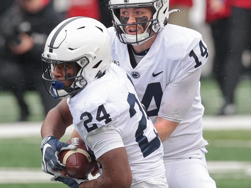 Dec 5, 2020; Piscataway, New Jersey, USA; Penn State quarterback Sean Clifford (14) hands off to running back Keyvone Lee (24) during the first quarter against the Rutgers Scarlet Knights at SHI Stadium. Mandatory Credit: Vincent Carchietta-USA TODAY Sports