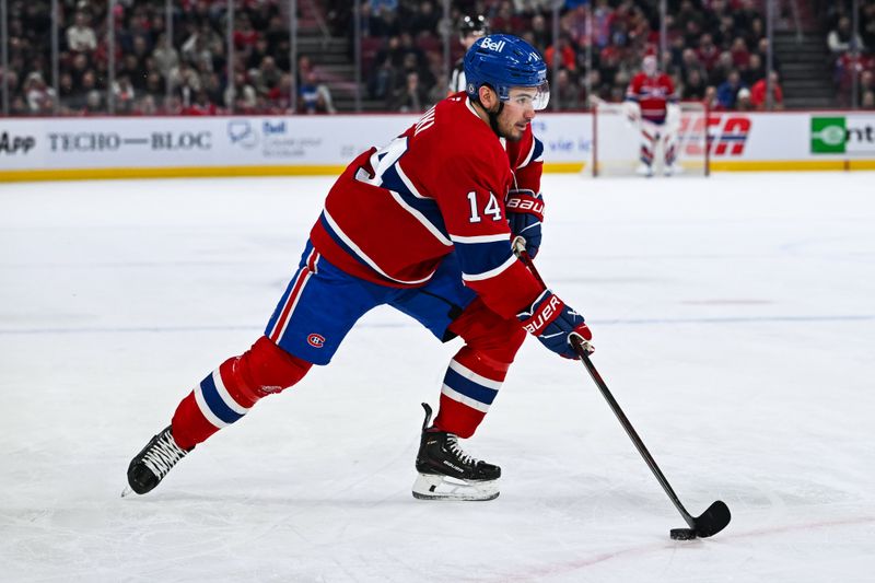 Jan 21, 2025; Montreal, Quebec, CAN; Montreal Canadiens center Nick Suzuki (14) plays the puck against the Tampa Bay Lightning during the first period at Bell Centre. Mandatory Credit: David Kirouac-Imagn Images