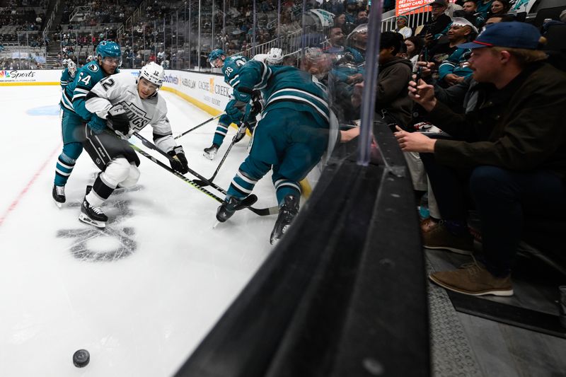 Oct 29, 2024; San Jose, California, USA; Los Angeles Kings left wing Trevor Moore (12) and San Jose Sharks center Mikael Granlund (64) watch the puck in the first period at SAP Center at San Jose. Mandatory Credit: Eakin Howard-Imagn Images