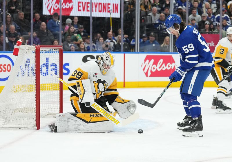 Apr 8, 2024; Toronto, Ontario, CAN; Toronto Maple Leafs left wing Tyler Bertuzzi (59) battles for the puck in front of Pittsburgh Penguins goaltender Alex Nedeljkovic (39) during the first period at Scotiabank Arena. Mandatory Credit: Nick Turchiaro-USA TODAY Sports