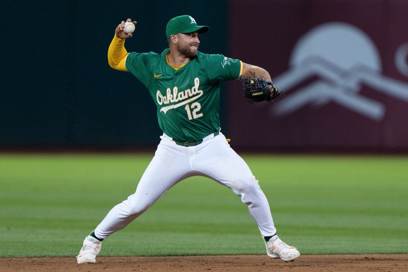 Aug 19, 2024; Oakland, California, USA; Oakland Athletics shortstop Max Schuemann (12) throws the baseball during the fifth inning against the Tampa Bay Rays at Oakland-Alameda County Coliseum. Mandatory Credit: Stan Szeto-USA TODAY Sports