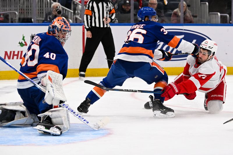 Nov 25, 2024; Elmont, New York, USA;   Detroit Red Wings center Dylan Larkin (71) scores a goal past New York Islanders goaltender Semyon Varlamov (40) defended by New York Islanders defenseman Isaiah George (36) during the third period at UBS Arena. Mandatory Credit: Dennis Schneidler-Imagn Images