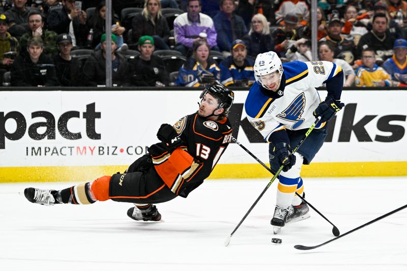 Mar 25, 2023; Anaheim, California, USA; Anaheim Ducks defenseman Simon Benoit (13) falls to the ice while defending against St. Louis Blues center Jordan Kyrou (25) during the second period at Honda Center. Mandatory Credit: Kelvin Kuo-USA TODAY Sports