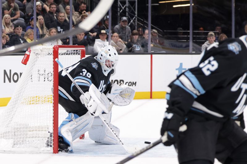 Oct 28, 2024; Salt Lake City, Utah, USA;  Utah Hockey Club goaltender Connor Ingram (39) tips the puck away from the goal during the third period against the San Jose Sharks at Delta Center. Mandatory Credit: Chris Nicoll-Imagn Images