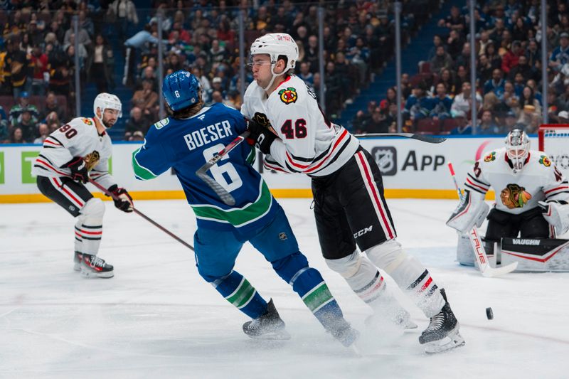 Mar 15, 2025; Vancouver, British Columbia, CAN; Chicago Blackhawks defenseman Louis Crevier (46) checks Vancouver Canucks forward Brock Boeser (6) in the first period at Rogers Arena. Mandatory Credit: Bob Frid-Imagn Images