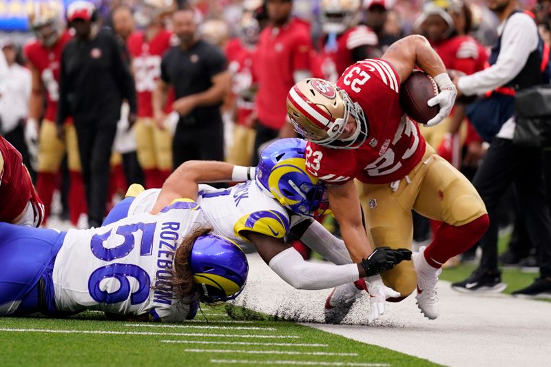 San Francisco 49ers running back Christian McCaffrey, right, is tackled by Los Angeles Rams linebacker Christian Rozeboom, left, and cornerback Derion Kendrick during the first half of an NFL football game Sunday, Sept. 17, 2023, in Inglewood, Calif. (AP Photo/Ashley Landis)