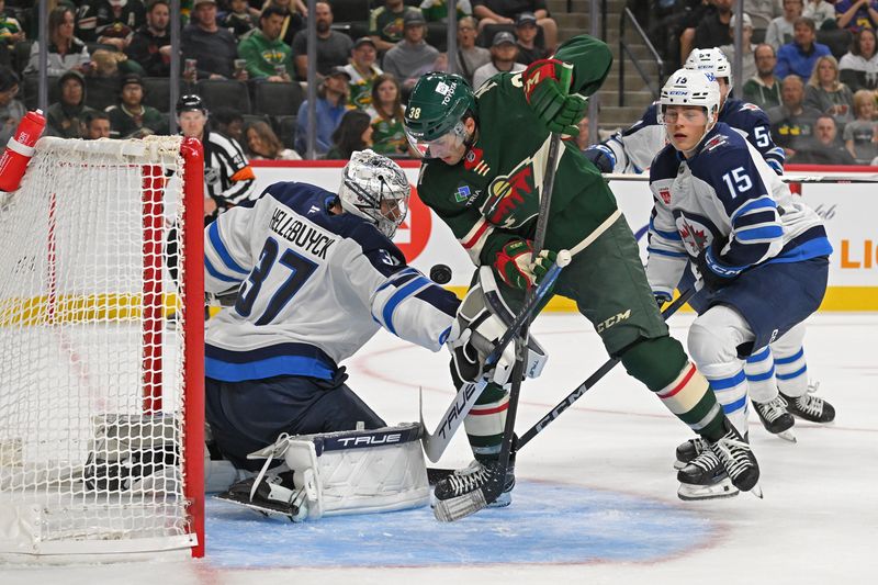 Sep 27, 2024; Saint Paul, Minnesota, USA;  Winnipeg Jets goalie Connor Hellebuyck (37) and Minnesota Wild forward Ryan Hartman (38) battle for a rebound during the second period at Xcel Energy Center. Mandatory Credit: Nick Wosika-Imagn Images

