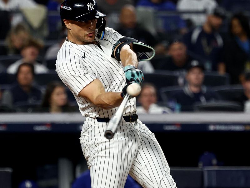 Oct 30, 2024; New York, New York, USA; New York Yankees designated hitter Giancarlo Stanton (27) hits a home run during the third inning against the Los Angeles Dodgers in game five of the 2024 MLB World Series at Yankee Stadium. Mandatory Credit: Vincent Carchietta-Imagn Images