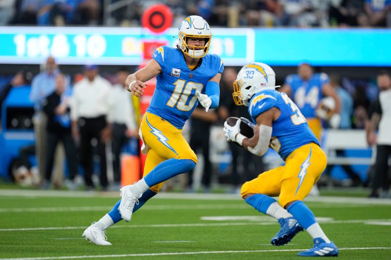 Los Angeles Chargers quarterback Justin Herbert (10) pitches to Chargers running back Austin Ekeler (30) during the first half of an NFL football game against the Dallas Cowboys, Monday, Oct. 16, 2023, in Inglewood, Calif. (AP Photo/Ashley Landis)