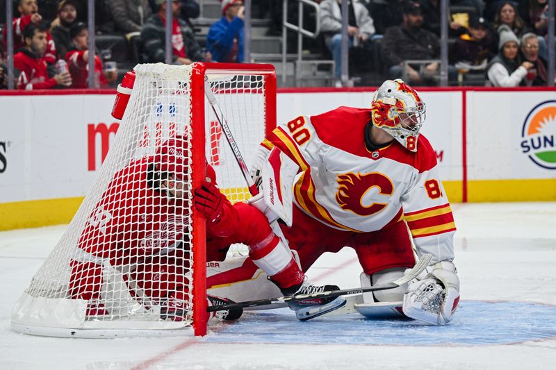 Nov 27, 2024; Detroit, Michigan, USA; Detroit Red Wings center Marco Kasper (92) gets tangled up in the net as Calgary Flames goaltender Dan Vladar (80) defends the net during the second period at Little Caesars Arena. Mandatory Credit: Tim Fuller-Imagn Images