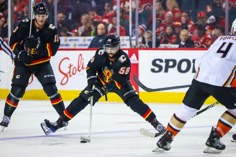 Apr 2, 2024; Calgary, Alberta, CAN; Calgary Flames defenseman Oliver Kylington (58) controls the puck against the Anaheim Ducks during the third period at Scotiabank Saddledome. Mandatory Credit: Sergei Belski-USA TODAY Sports